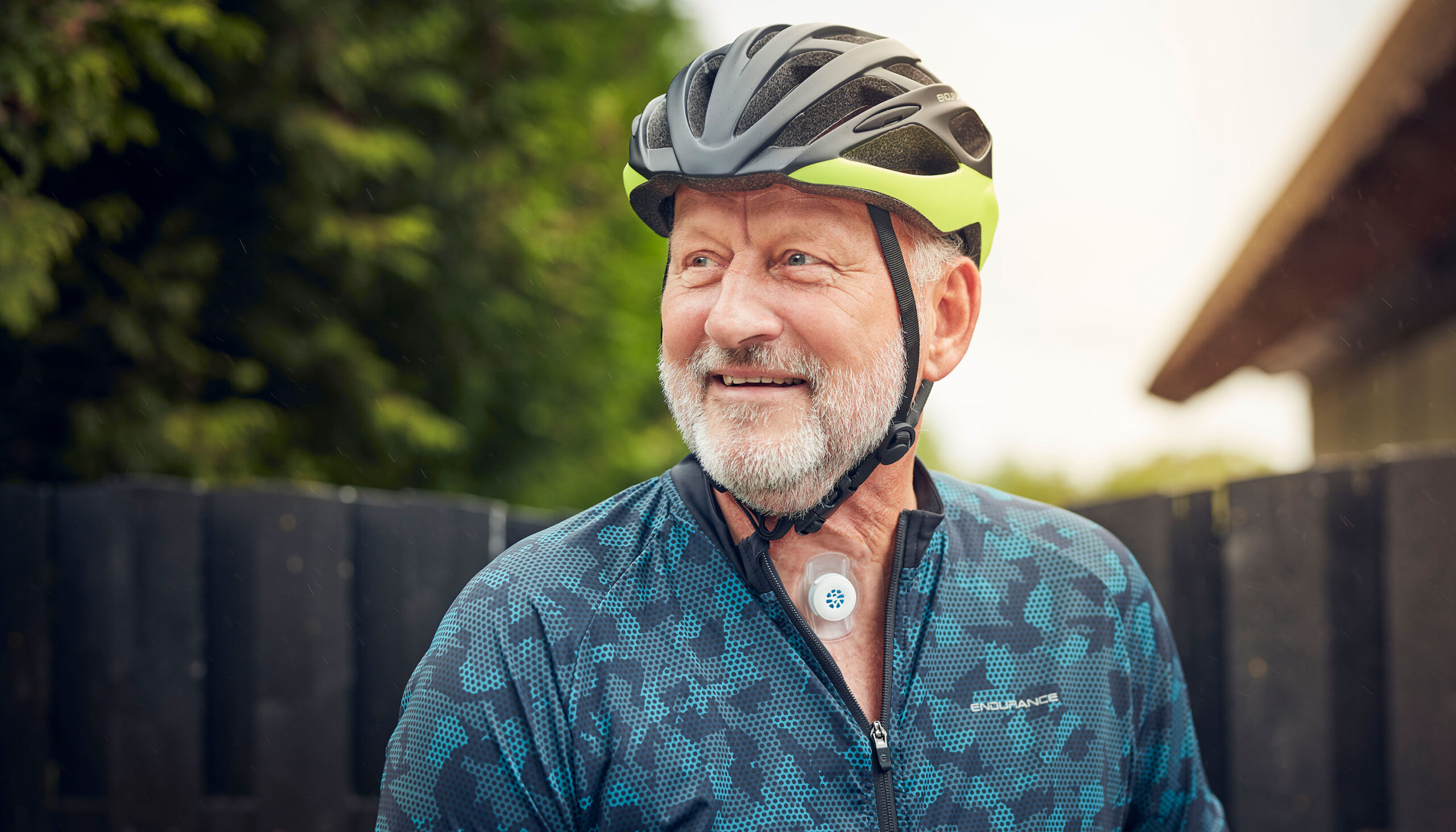 Man with a neck stoma wearing a helmet and using Provox life energy HME.